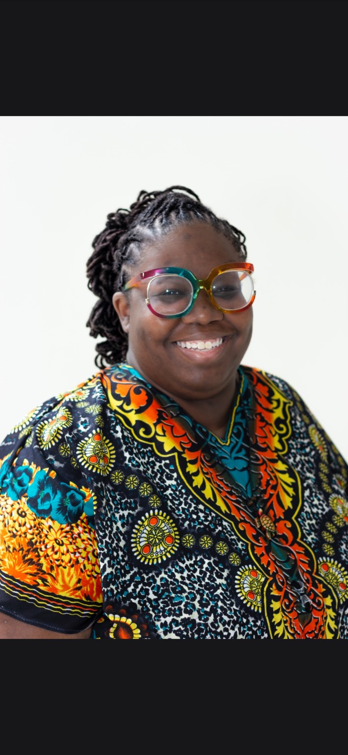 Shakeema Funchess, creator of We Know the W, smiling in colorful glasses and a patterned shirt